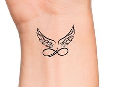 an image of a tattoo with wings on the side of a woman's arm