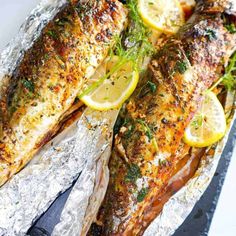 grilled fish with lemons and herbs on foil