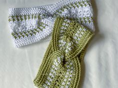 two crocheted scarves are laying next to each other on a white surface