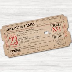 two tickets with hearts on them sitting on top of a wooden table