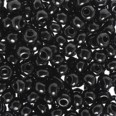 many black beads are arranged together on a white surface