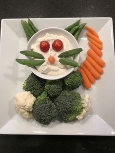 a white plate topped with carrots, cauliflower and a face made out of vegetables