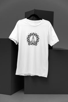 Embrace the serene energy of the cosmos with our "Divine Harmony" t-shirt. Crafted with comfort and spirituality in mind, this tee features a captivating illustration of two hands delicately clasped together, forming a symbol of unity and peace. Nestled between the palms lies a radiant flower, symbolizing vitality, growth, and enlightenment. Each detail on this shirt is meticulously designed to evoke a sense of tranquillity and spiritual connection. Made from premium quality fabric, it offers a White Spiritual Graphic T-shirt, White Graphic Print T-shirt For Yoga, White Relaxed Fit Yoga T-shirt, White Relaxed Fit T-shirt For Yoga, Spiritual Person, Art Tshirt, Spiritual Meditation, Beacon Of Light, The Palms