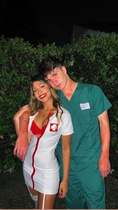 a man and woman dressed up as nurses standing next to each other in front of bushes