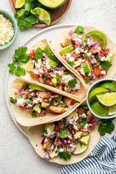 three tacos on a cutting board with vegetables