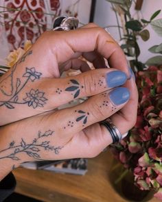 two hands with tattoos on their fingers