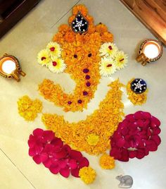 an arrangement of flowers and candles on the floor for diwaling or decorating