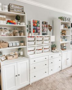 a room filled with lots of white cabinets and shelves full of crafting supplies on top of them