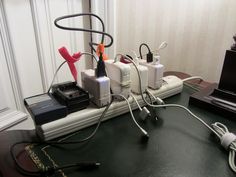 several electronic devices connected to each other sitting on a table with wires and cords in front of them