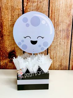 a white balloon sitting on top of a black and white box with confetti in it