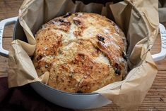 a loaf of bread sitting in a pan on top of a wooden table