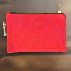 a red pouch sitting on top of a wooden table