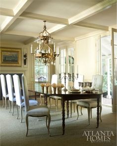 an elegant dining room with chandelier and chairs