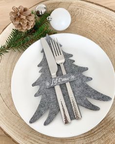 a white plate topped with a fork and knife next to a christmas tree ornament