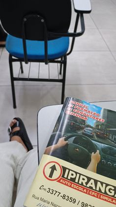 a magazine sitting on top of a table next to a person's feet and chair