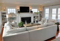 a living room filled with furniture and a flat screen tv mounted on the wall above a fire place