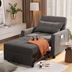 a living room with a gray recliner and orange throw blanket on the ottoman next to it