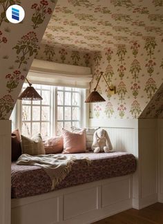 a window seat in the corner of a room with floral wallpaper on the walls