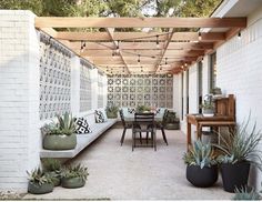 an outdoor dining area with potted plants on the patio