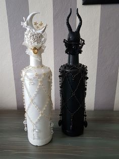 two black and white vases sitting next to each other on top of a table