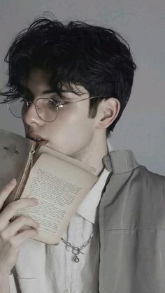 a man with glasses holding an open book