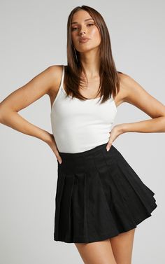 Give off major sporty and trendy vibes in the Cailin Pleated Skirt! This mini tennis skirt is a staple piece that you need in your wardrobe. It has a flattering high-waist fit and is perfect to wear all year 'round for any occasion. You can dress it up with a crop top and heeled sandals, or down with an oversized tee, chunky sneakers and a 90s mini bag!Product DetailsInvisible side seam zipperPleated detailNo liningNo pocketsSize & FitSize 8 length: 41cm / 16.1inModel is wearing size 8 AU / Black Summer Skirt Outfit, Black Summer Skirt, Mini Tennis Skirt, Black Pleated Mini Skirt, Skirt Outfits Summer, Cute Crop Tops, Chunky Sneakers, Summer Skirts, Pleated Mini Skirt