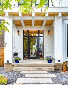 a white house with steps leading up to the front door and entry way that leads into it