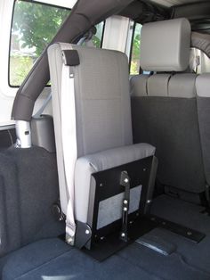 the back seat of a van with two seats folded down and one arm rest up