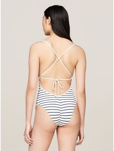 Tommy Hilfiger women's swimwear. Our strappy one-piece swimsuit is styled from quick-dry textured pique recycled fabric that's just as comfortable on the sand as in the sea.  Material: 88% Recycled Nylon ,  Polyamide, 12% Elastane. Summer Bodysuit With Tie Back For Beach Season, White Strappy Back Swimwear For Swimming, Tommy Hilfiger Swimwear For Spring Beachwear, Tommy Hilfiger Beachwear For Spring, Tommy Hilfiger Spring Beachwear, Beachwear Bodysuit With Adjustable Straps For Beach Season, Tommy Hilfiger Beachwear, Summer Poolside Bodysuit With Tie Back, White Swimwear With Adjustable Strappy Back