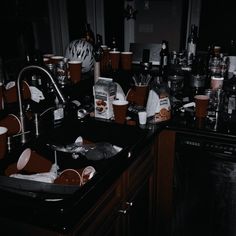 a kitchen sink filled with lots of cups