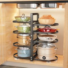 a kitchen cabinet filled with pots and pans