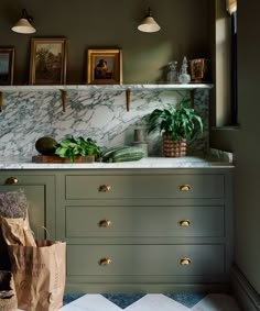 a kitchen with marble counter tops and green cabinets