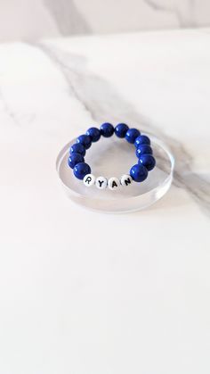 Hi everyone, welcome to my store.   These are a couple of named bracelets which can be custom made for your child! Can be for boys or girls! The first bracelet in the picture is 7 cm in length and is made from 0.5 (colour of your choice but in the picture) purple/coral plastic beads, 0.6 cm plastic letter beads, 1.9 cm love heart beads and from 0.6 mm strong and stretchy elastic.  All items are handmade and come in gift box or organza bag as standard and will be sent out and should arrive within Bracelet Letter Beads, Picture Purple, Purple Coral, Plastic Letters, Minimalist Gifts, Id Bracelets, Letter Beads, Name Bracelet, Plastic Beads