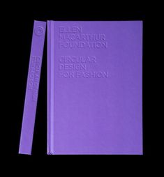 a purple book sitting on top of a black table next to a pair of scissors