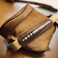 a brown purse sitting on top of a wooden table