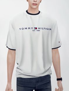 a young man wearing a tommy hilfiger t - shirt