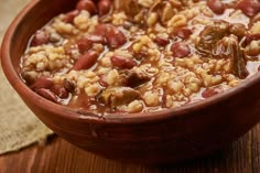 a bowl filled with beans and rice on top of a wooden table