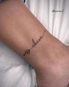 a woman's foot with the word mama written on it and an arrow tattoo