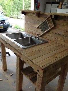 an outdoor kitchen made out of pallet wood with a sink on the counter top