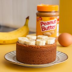 a peanut butter and banana cake on a plate next to an egg yogurt jar