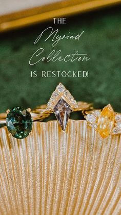 three different colored rings sitting on top of a gold fan with the words, the diamond collection is restored