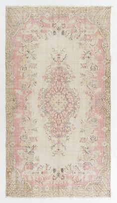 an antique rug with pink and beige colors