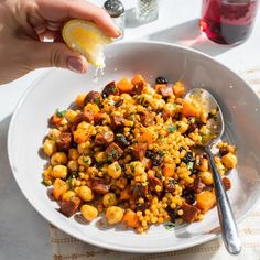 a white bowl filled with food next to a glass of wine