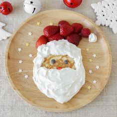 a plate with some strawberries on it and a face made out of whipped cream