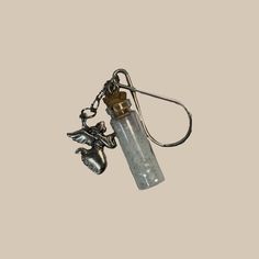 a glass bottle with a metal keychain hanging from it's side on a white background