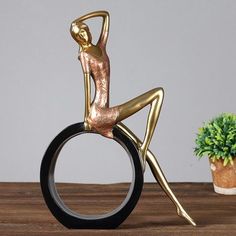 a gold figurine sitting on top of a black ring