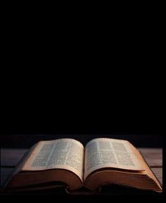 an open book sitting on top of a wooden table