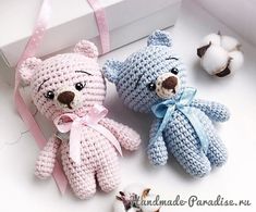 two crocheted teddy bears sitting next to each other in front of a box