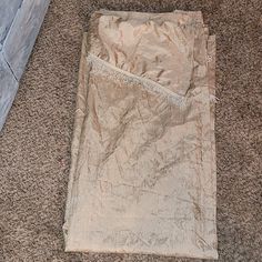 a white blanket laying on the floor next to a wooden door with a blue handle