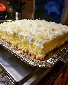 a piece of cake sitting on top of a metal pan covered in white frosting